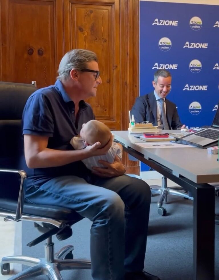 Carlo Calenda tiene in braccio il figlio della collega ad una riunione